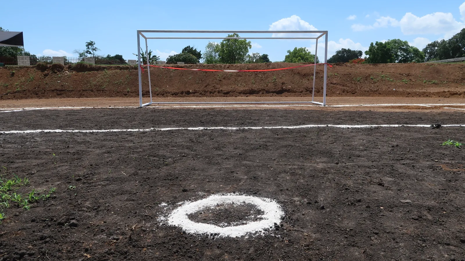 Football goal on an unfinished dirt pitch marked out for the new centre in Lusaka, Zambia